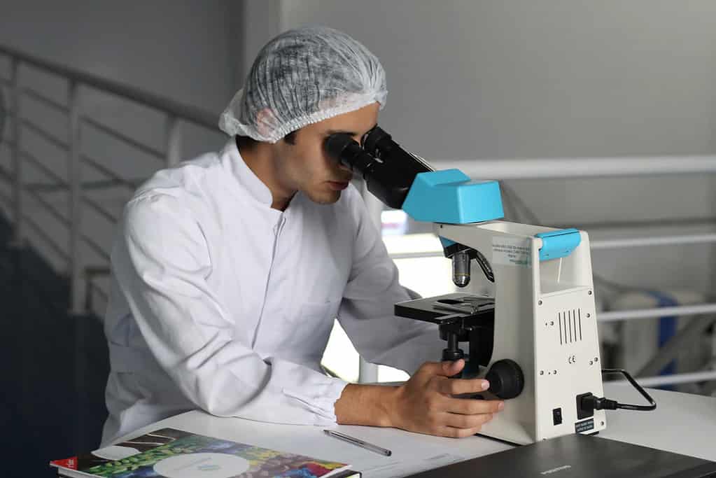 man conducting kratom research with microscope