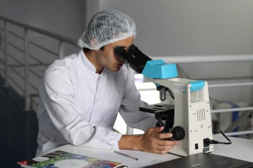man conducting kratom research with microscope